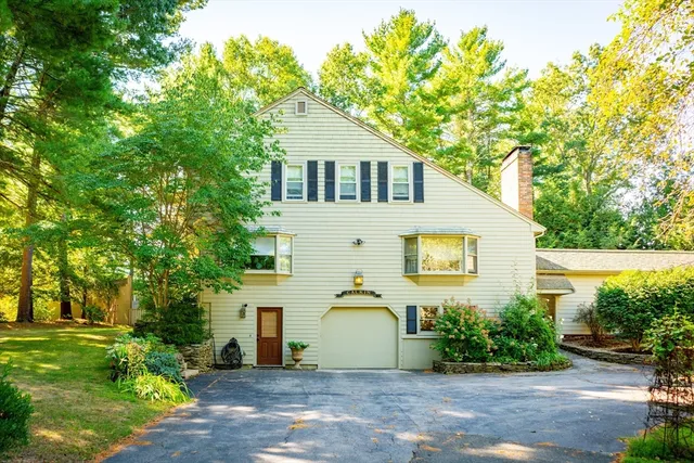 a front view of a house with a yard and trees