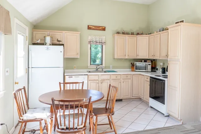 a kitchen with a refrigerator a stove a dining table and chairs