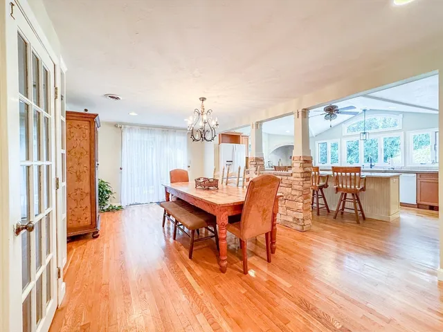 a dining room with furniture a chandelier and wooden floor