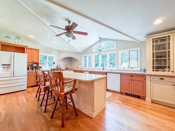 a dining hall with stainless steel appliances granite countertop a dining table chairs and window