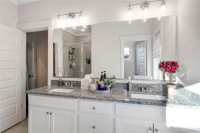 a en suite bathroom with a granite countertop sink and a mirror
