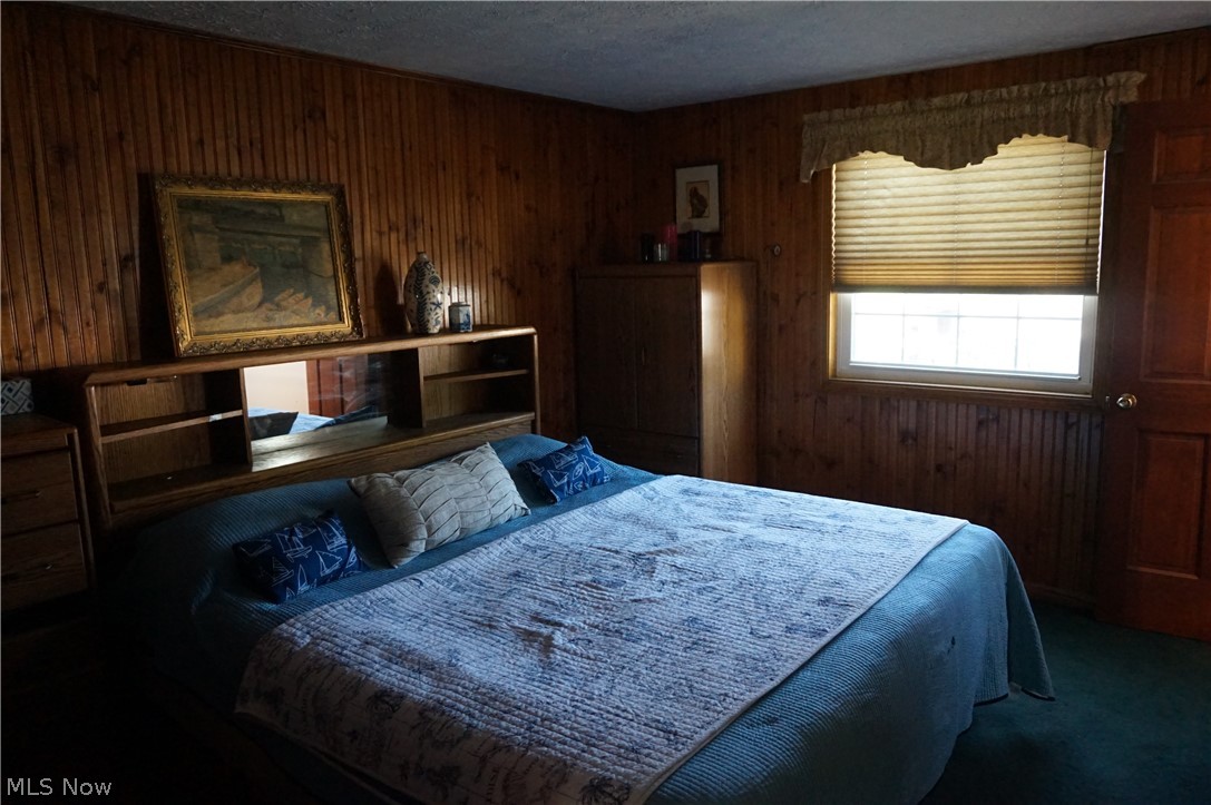 6019 New London Road Ashtabula, OH 44004 - Photo 10 of 47 Carpeted bedroom featuring a textured ceiling and wood walls