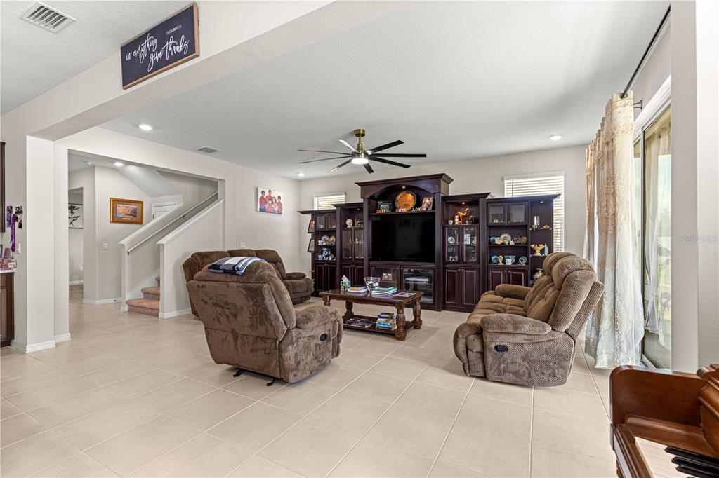 8142 Southwest 59th Avenue Ocala, FL 34476 - Photo 19 of 54 a living room with furniture a flat screen tv and a large window