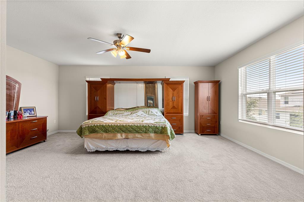 8142 Southwest 59th Avenue Ocala, FL 34476 - Photo 22 of 54 a bedroom with a bed and a chandelier