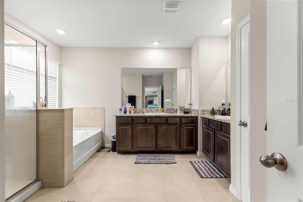8142 Southwest 59th Avenue Ocala, FL 34476 - Photo 28 of 54 a large bathroom with a tub a double vanity sink and mirror