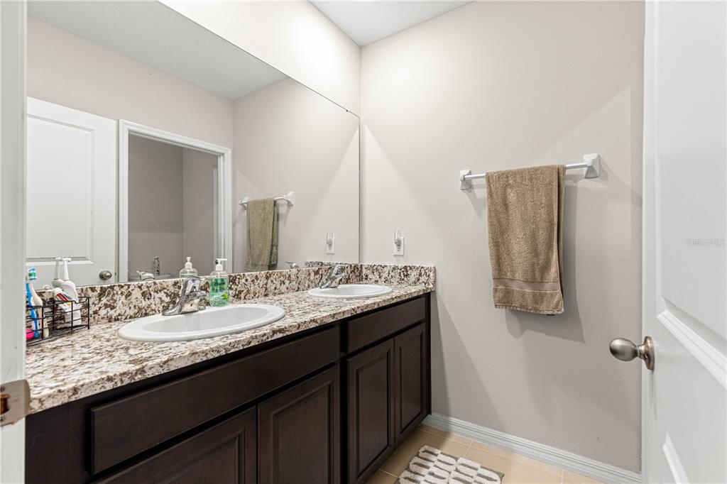 8142 Southwest 59th Avenue Ocala, FL 34476 - Photo 34 of 54 a bathroom with a granite countertop sink and a mirror