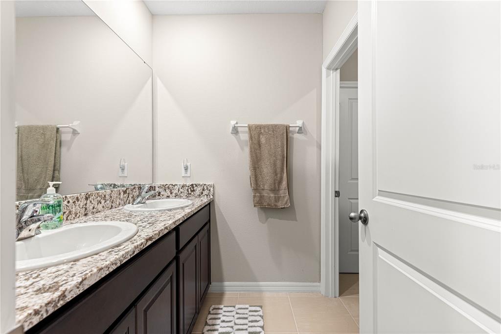 8142 Southwest 59th Avenue Ocala, FL 34476 - Photo 35 of 54 a bathroom with a granite countertop sink and a mirror
