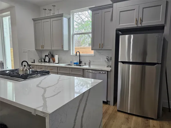 a kitchen with stainless steel appliances granite countertop a refrigerator sink and stove