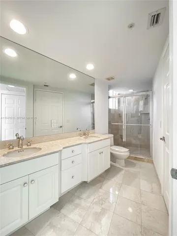 a large bathroom with a large mirror vanity and a shower