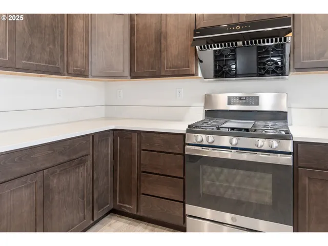 a kitchen with granite countertop a stove and cabinets