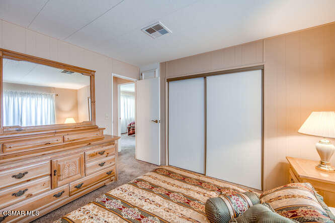 6480 Katherine Road, Unit 121 Simi Valley, CA 93063 - Photo 25 of 34 a bedroom with a bed and a lamp on dresser