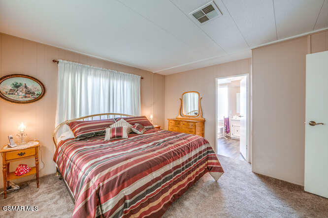 6480 Katherine Road, Unit 121 Simi Valley, CA 93063 - Photo 27 of 34 a bedroom with a bed and a chandelier