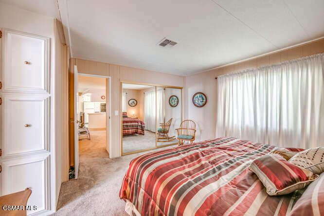 6480 Katherine Road, Unit 121 Simi Valley, CA 93063 - Photo 28 of 34 a bedroom with a bed and a chandelier