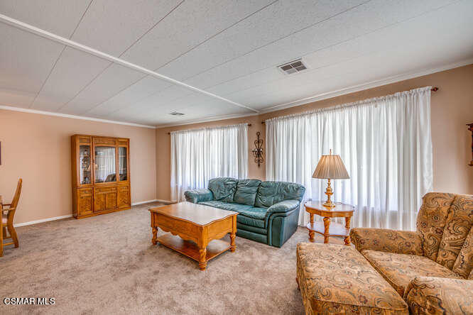 6480 Katherine Road, Unit 121 Simi Valley, CA 93063 - Photo 9 of 34 a living room with furniture and a large window