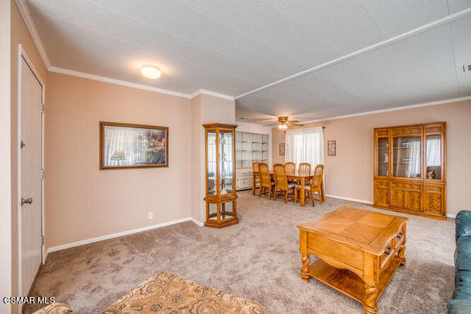 6480 Katherine Road, Unit 121 Simi Valley, CA 93063 - Photo 10 of 34 a living room with furniture and a dining table with projector the screen