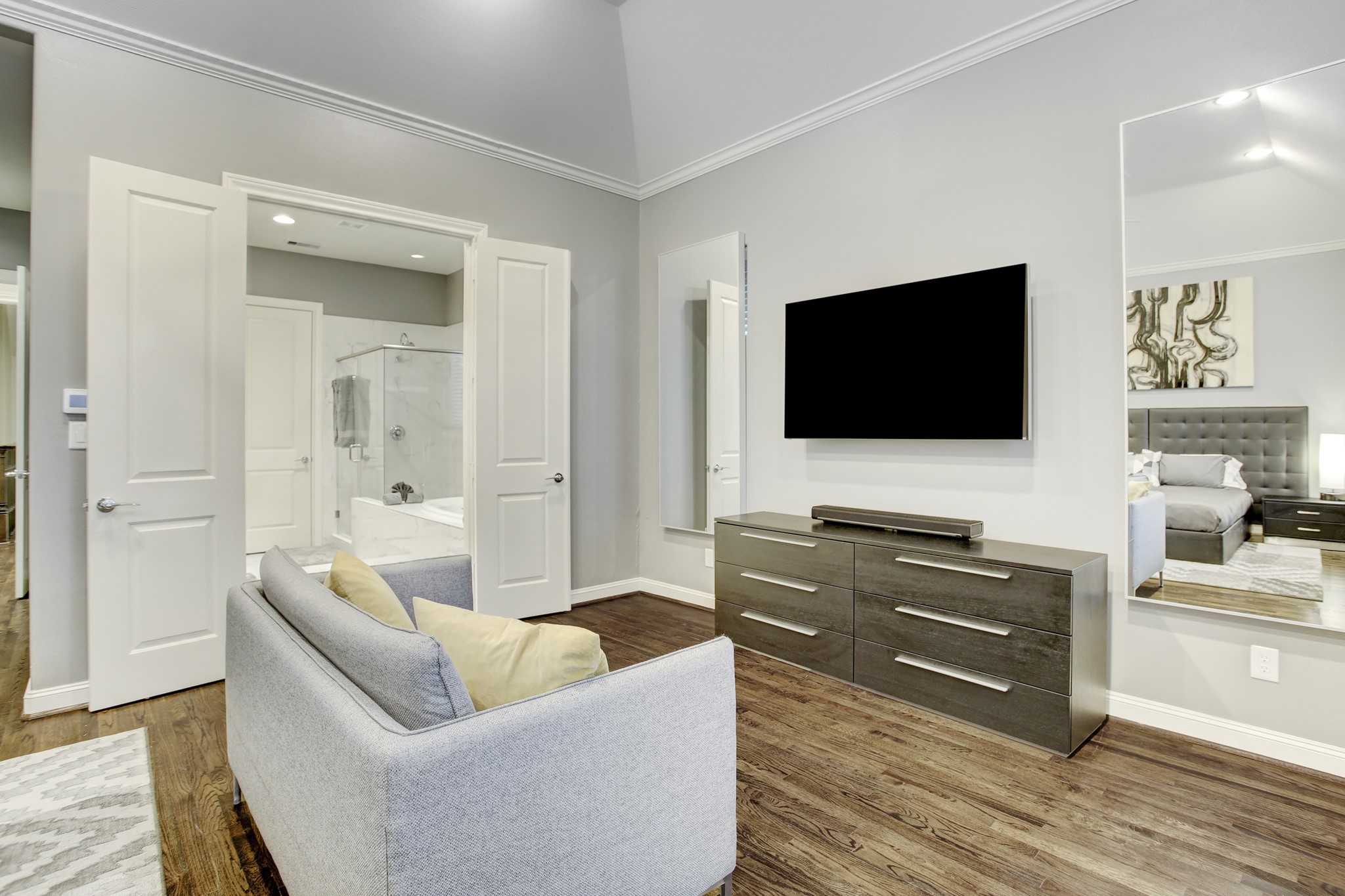 5506 Darling Street Houston, TX 77007 - Photo 11 of 23 Sitting Area in Primary Suite showcases a loveseat and a dresser with TV above, and 2 large mirrors flanking the TV. The double doors open to the sumptuous Primary EnSuite Bath & 2 Walk-in Closets.