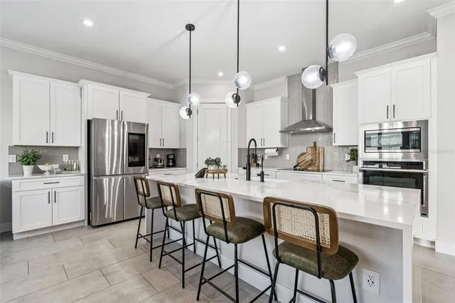 a large kitchen with stainless steel appliances kitchen island granite countertop a stove a sink and a refrigerator