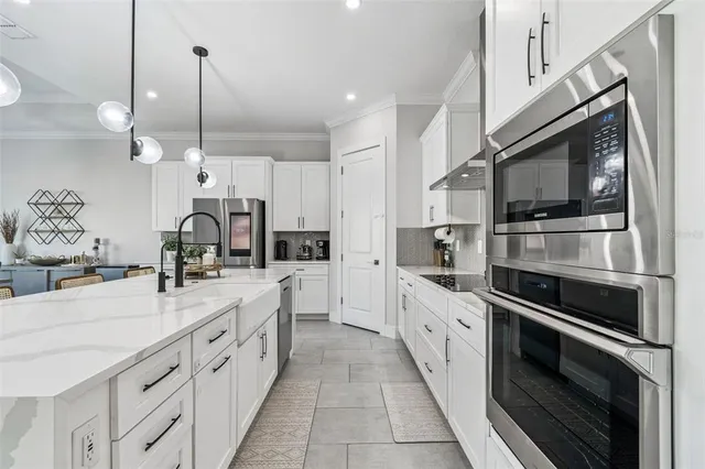 a large kitchen with stainless steel appliances lots of counter space and a sink
