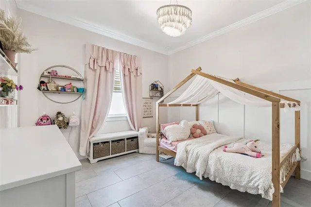 a bedroom with a bed and a flat tv screen on dresser