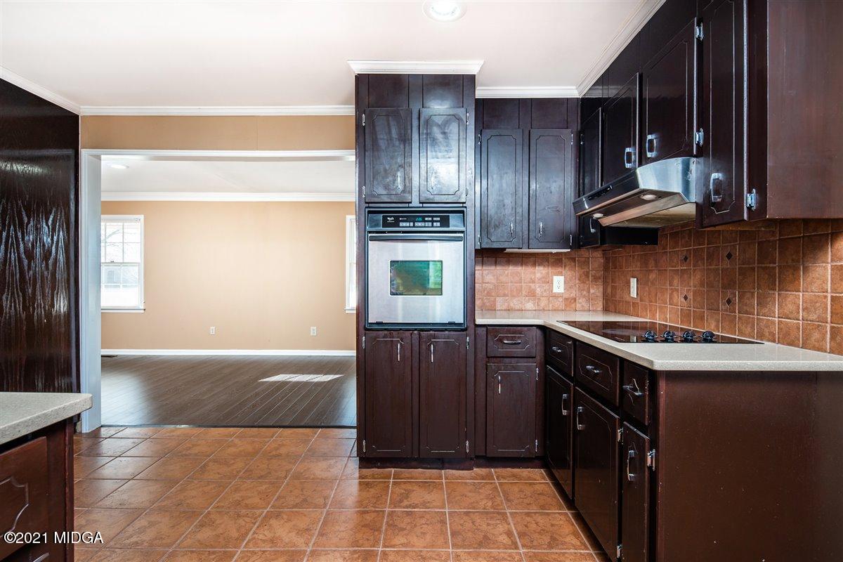 3309 Sandy Circle Macon, GA 31216 - Photo 13 of 35 a kitchen with granite countertop stainless steel appliances wooden cabinets and a sink