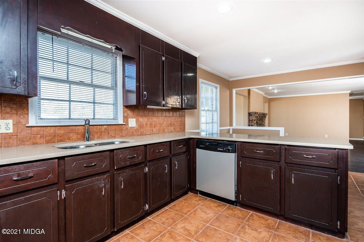 3309 Sandy Circle Macon, GA 31216 - Photo 15 of 35 a kitchen with stainless steel appliances granite countertop wooden cabinets a sink and dishwasher with wooden floor
