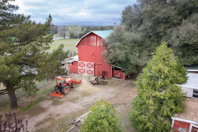 an aerial view of a house with a yard and tree s