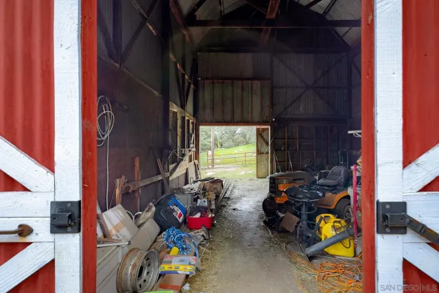 a view of a backyard with table and chairs potted plants and large tree