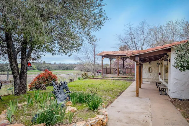 a view of a backyard with garden and patio