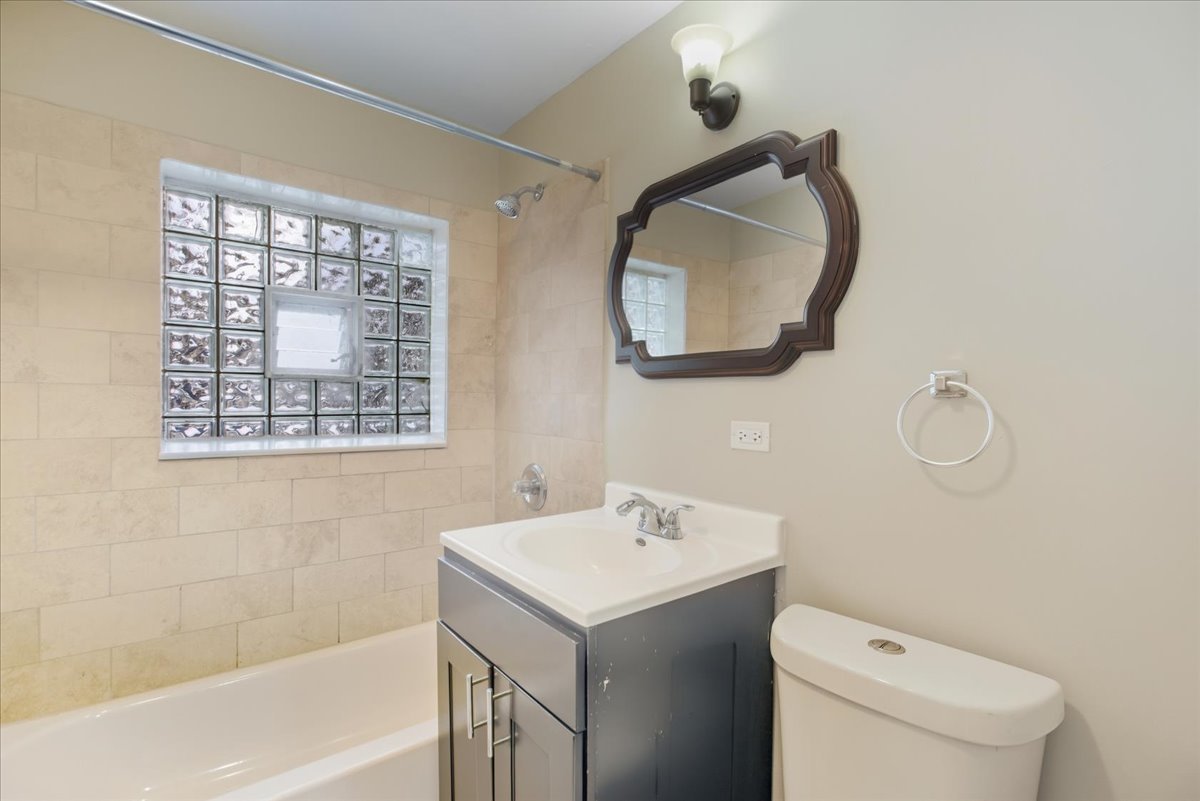 337 Custer Avenue, Unit G Evanston, IL 60202 - Photo 9 of 11 a bathroom with a sink mirror vanity and toilet