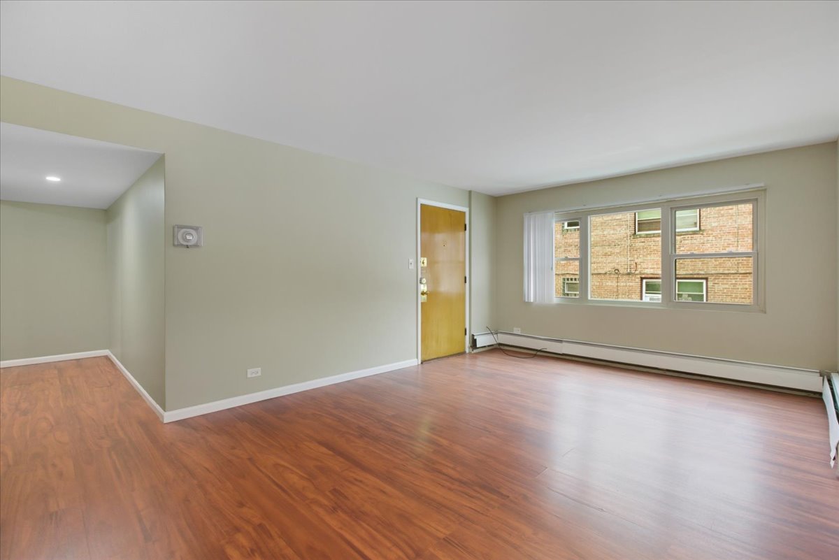 337 Custer Avenue, Unit G Evanston, IL 60202 - Photo 10 of 11 an empty room with wooden floor and windows