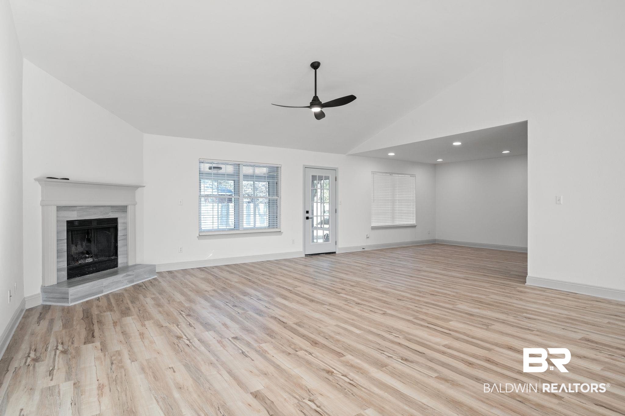 136 Destrehan Road Fairhope, AL 36532 - Photo 3 of 44 Unfurnished living room featuring a tile fireplace, high vaulted ceiling, light wood-type flooring, and ceiling fan