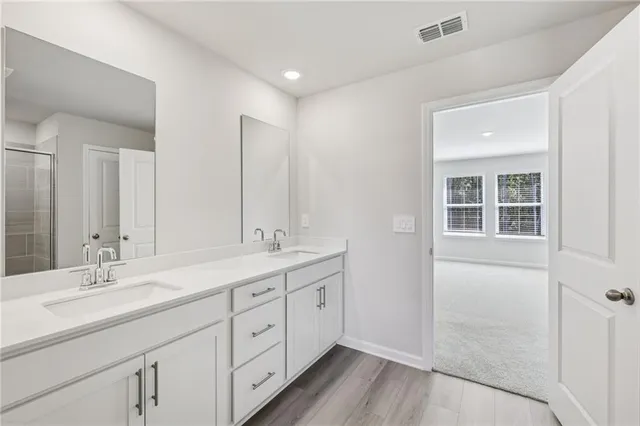 a spacious bathroom with a double vanity sink a mirror and a