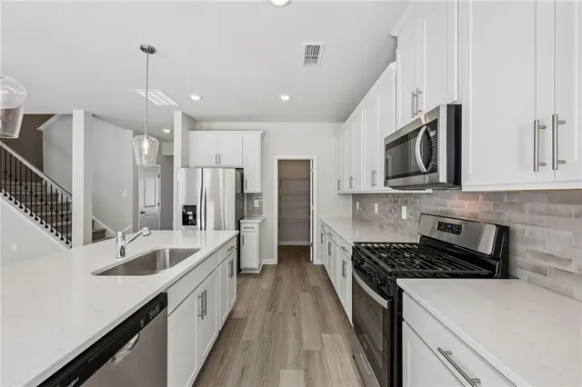 a kitchen with stainless steel appliances a sink stove and refrigerator