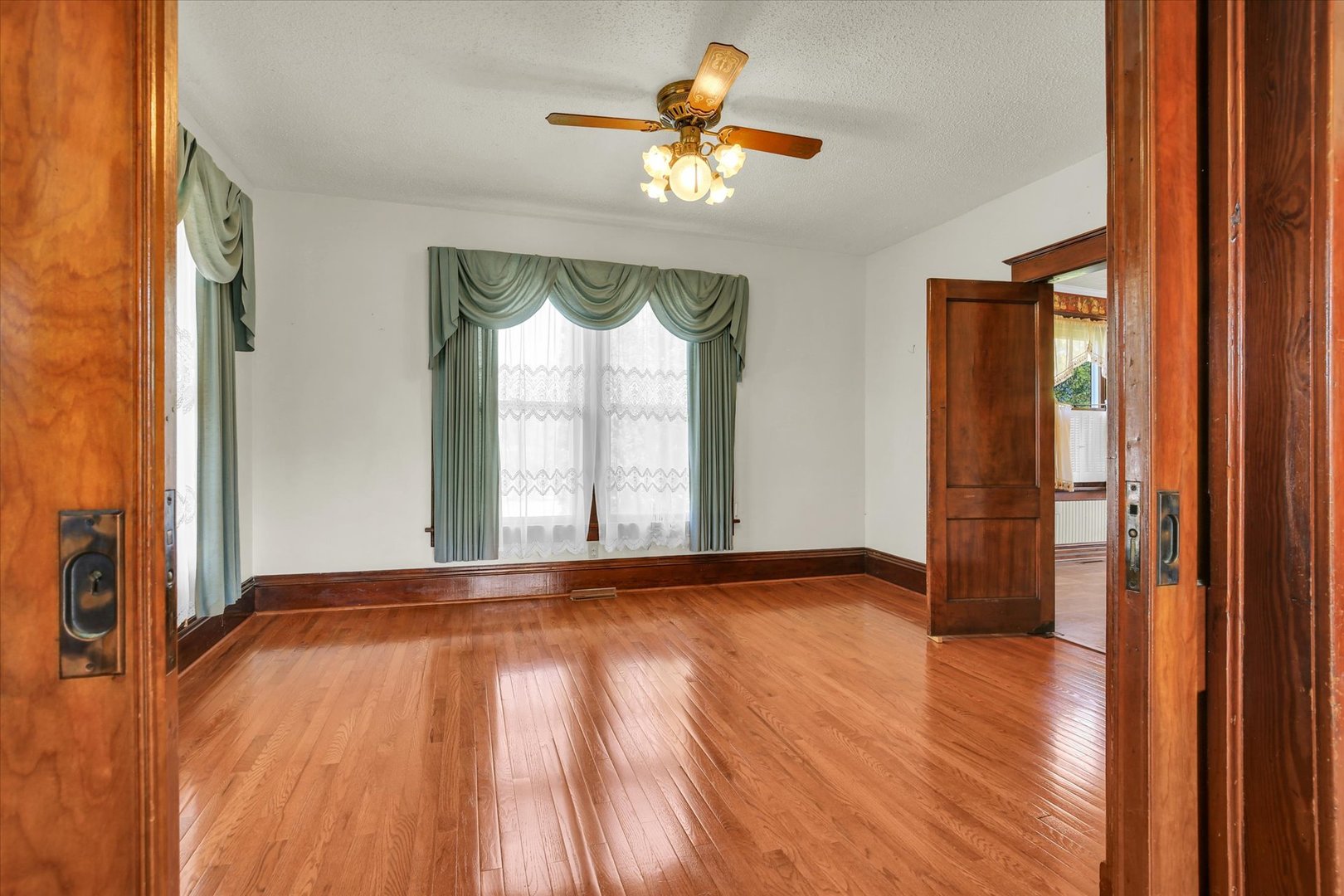 430 Indiana Avenue De Land, IL 61839 - Photo 14 of 48 a view of an empty room with a window and wooden floor