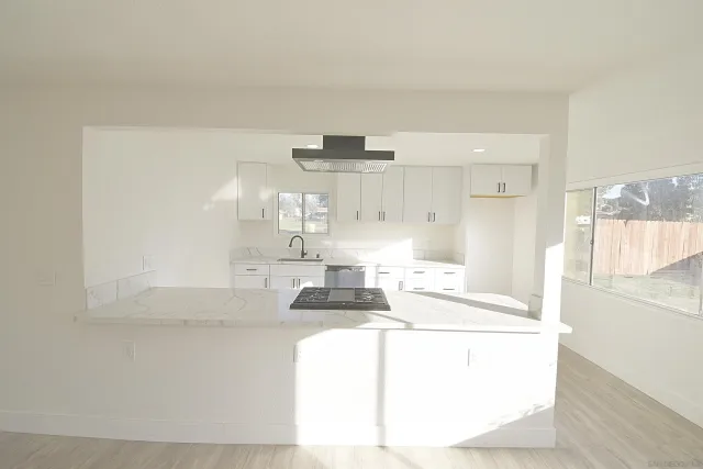 a kitchen with granite countertop a sink and a stove top oven