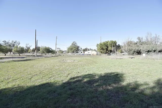 a view of a field with trees in background