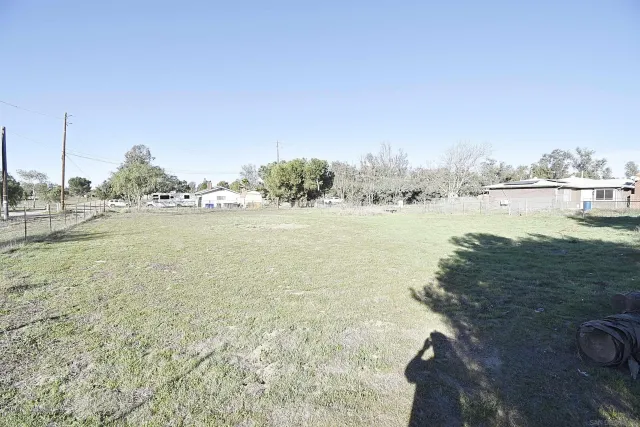 a view of a field with trees in the background