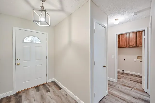 a view of a hallway with wooden floor and closet