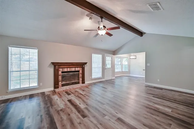 wooden floor fireplace and windows in an empty room