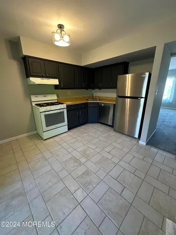 a kitchen with stainless steel appliances a stove a sink and a refrigerator