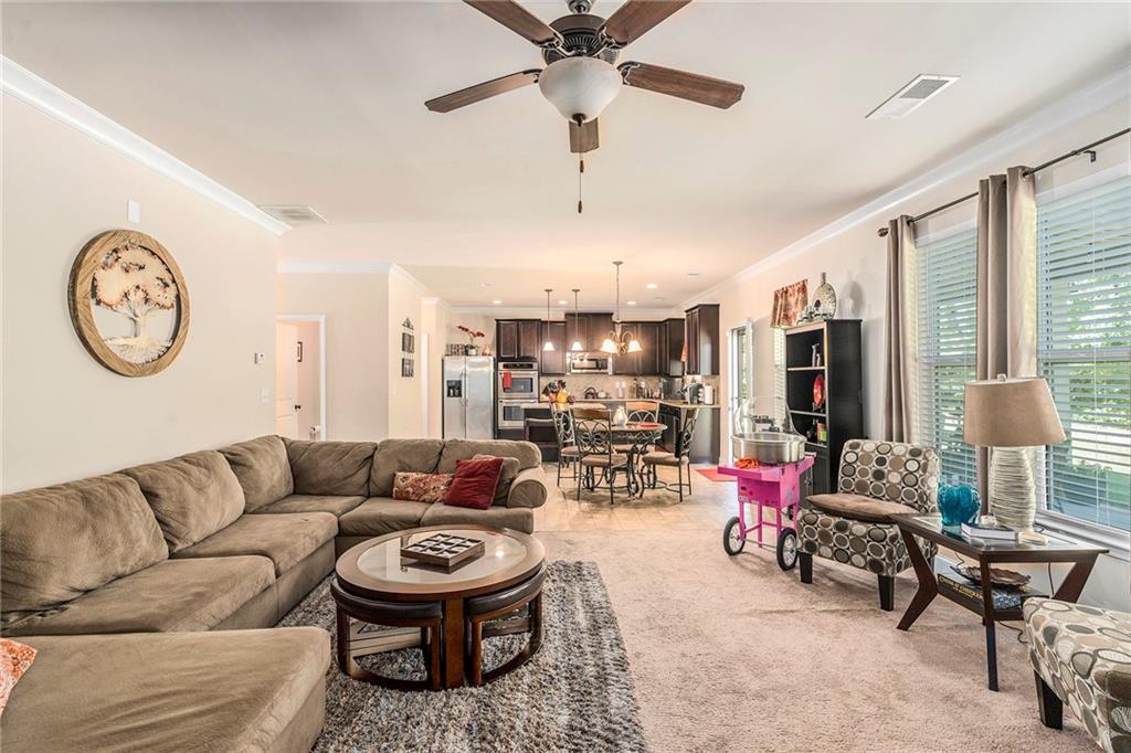 1419 Stone Ridge Court Hampton, GA 30228 - Photo 15 of 31 a living room with furniture a clock and a large window