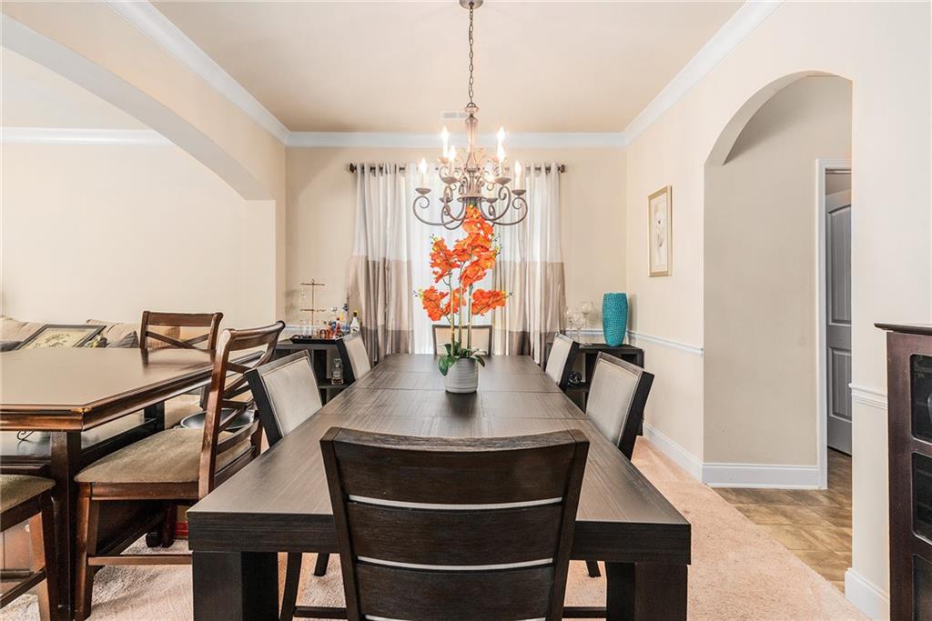 1419 Stone Ridge Court Hampton, GA 30228 - Photo 5 of 31 a view of a dining room with furniture a chandelier and wooden floor