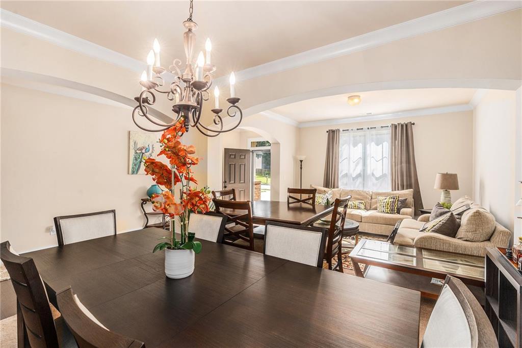 1419 Stone Ridge Court Hampton, GA 30228 - Photo 6 of 31 a living room with couches a table and chairs with wooden floor