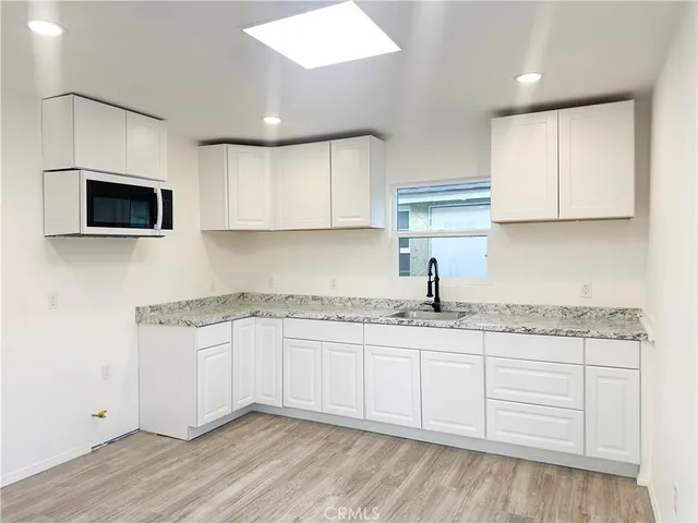 a kitchen with granite countertop a sink and a stove top oven