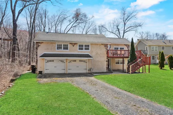 a view of a front of a house with a yard and garage
