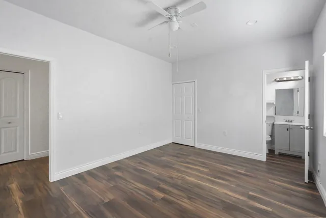 a view of an empty room with closet and a window