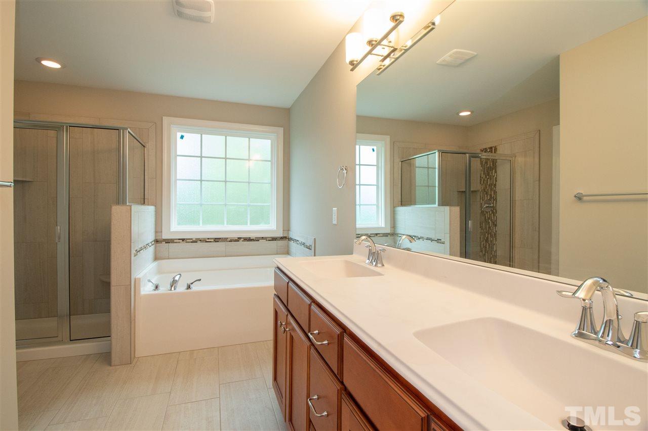 4202 Prelude Street Raleigh, NC 27616 - Photo 14 of 21 Master bathroom with separate tub/shower, dual vanities with large drawer bank, separate water closet, tile flooring and tile shower & tub surround