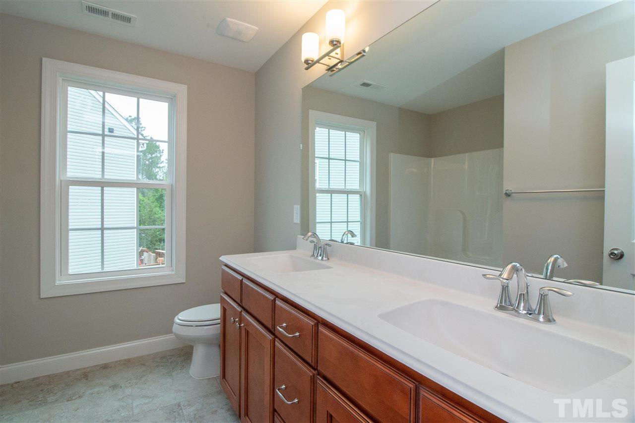 4202 Prelude Street Raleigh, NC 27616 - Photo 17 of 21 Shared hall bath features 2 sinks, drawer bank, combo tub/shower, tile flooring, great window for light!