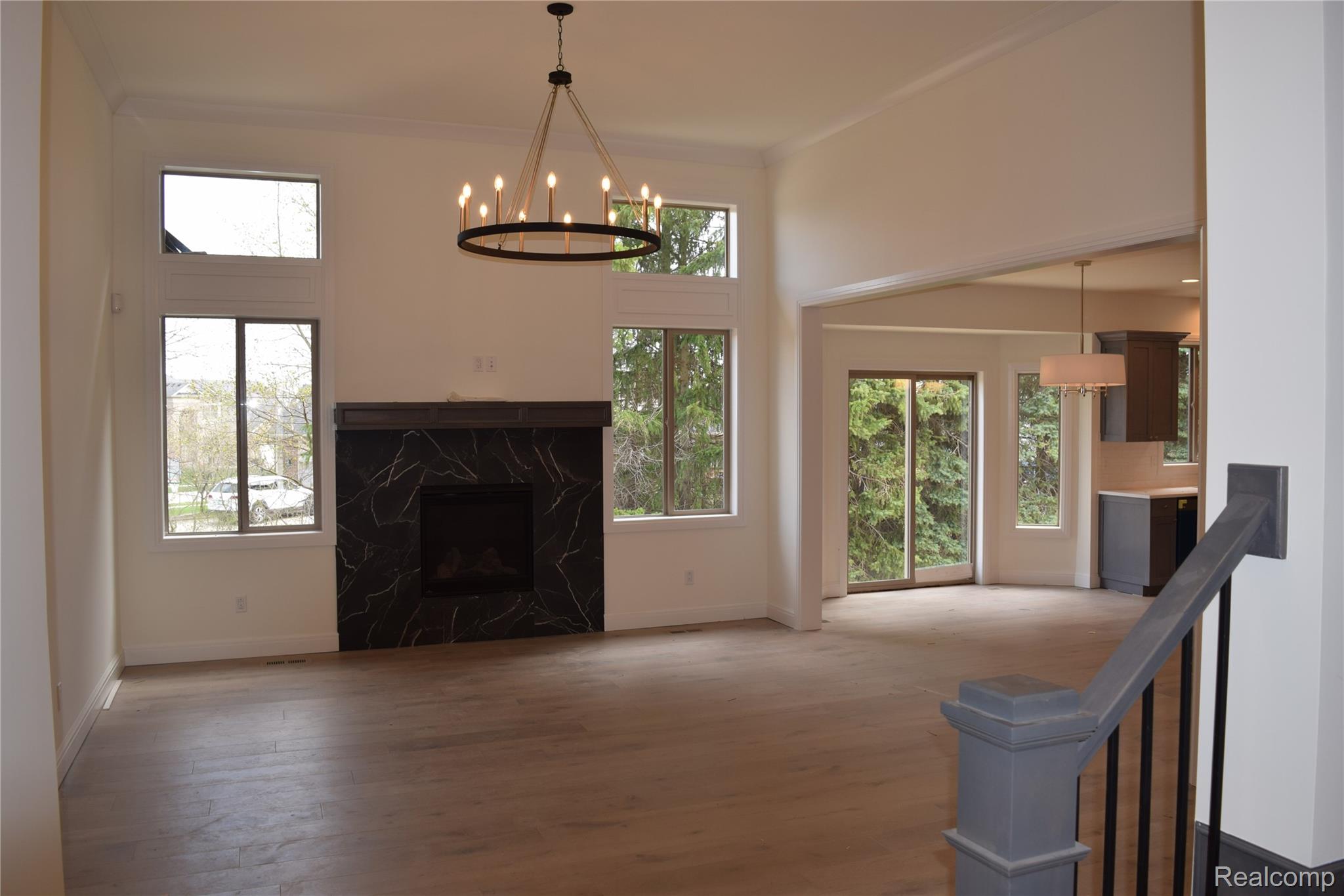 3093 Raffler Drive Rochester, MI 48307 - Photo 15 of 34 Unfurnished living room with a chandelier, a high end fireplace, and wood finished floors