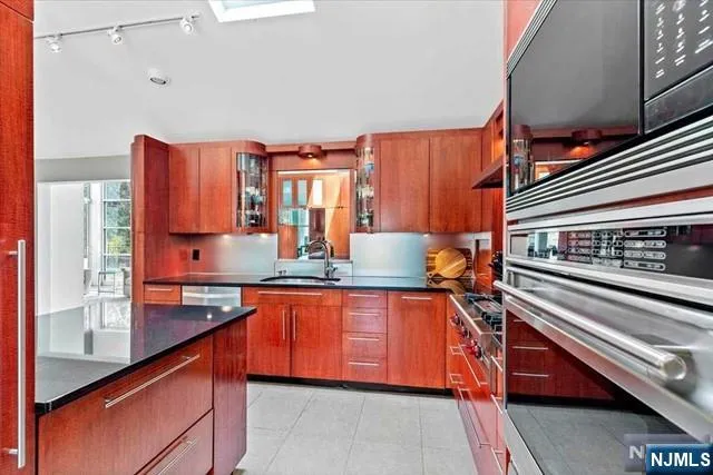 a kitchen with stainless steel appliances granite countertop a sink and cabinets